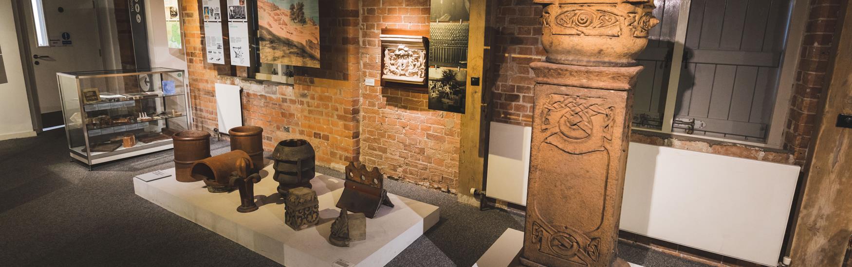 Objects on display in museum, brick wall behind