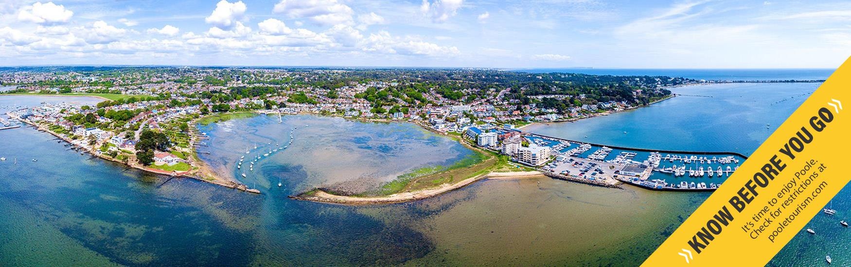 Stunning aerial shot of sandbanks in Poole with the know before you go Banner