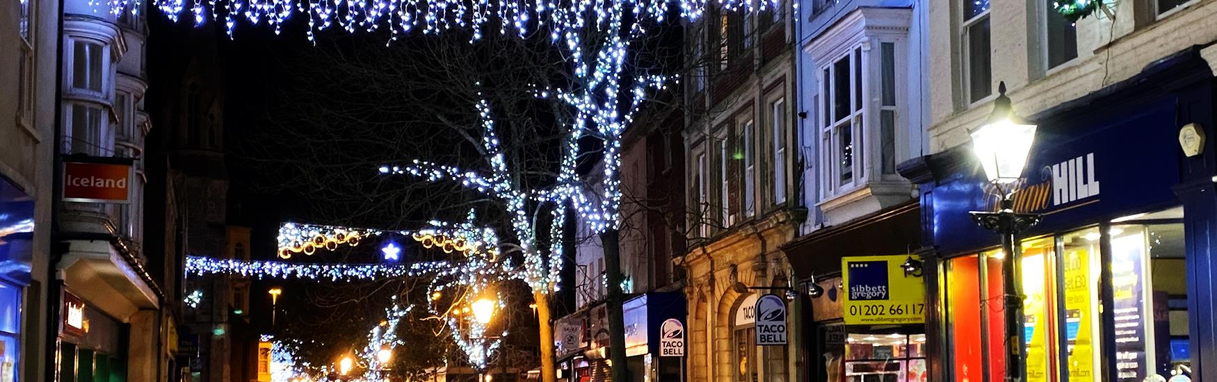 Kid running through the high street with christmas lights