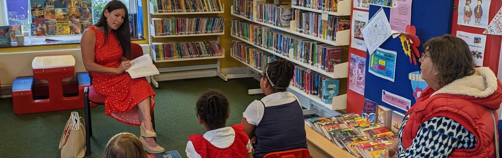 Woman reading to children at library in Poole