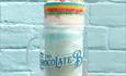 Bubblegum blast flavoured milkshake held against a blue brick wall