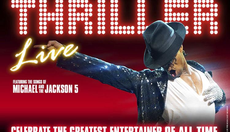 Thriller Live, Michael Jackson pointing in pose with arm out to side, other hand on chest with white glitter glove, wearing black hat with head lookin