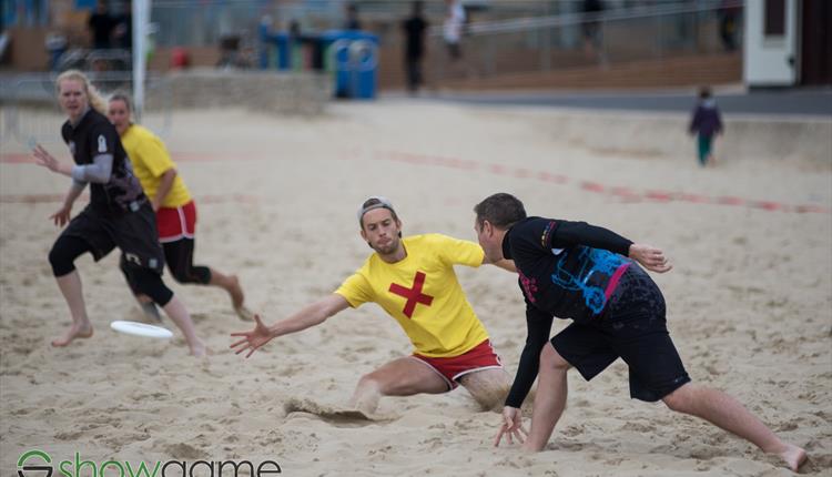 4 people running in the sand (photo courtesy of The Showgame)