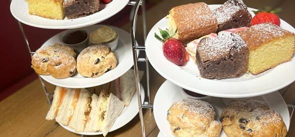 Afternoon tea with plates of cakes and sandwiches 