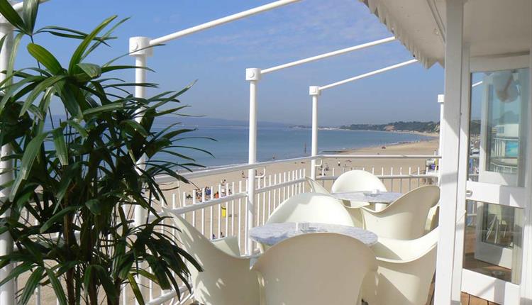 White table and chairs on the balcony overlooking the stunning views of Bournemouth beach and coastline