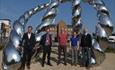Image of 5 people standing proudly in front of the Bottle Knot Sculpture