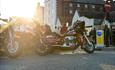 Sun peeping over parked mortorbike at Poole
