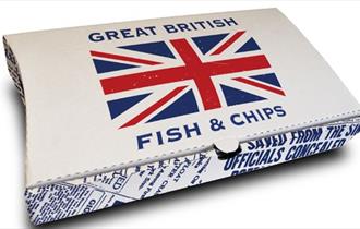 A box of fish and chips with a Great Britain flag in the middle