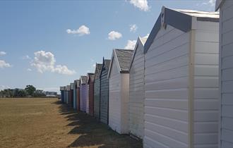 Colourful array of beach huts lined up along Hamworthy park in Poole