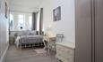 Spacious double bedroom with grey and white tones throughout