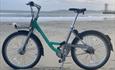 One of the Beryl bikes parked up on the beach with Bournemouth pier behind them