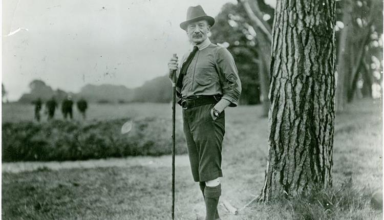 Historic picture with Baden Powell, (founder of the scouting movement) standing next to a tree.