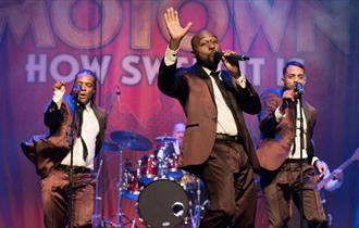 Image of Motown band on stage with matching suits