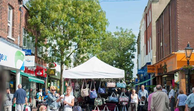 Visitors and shoppers walking around Poole market