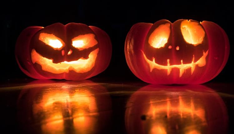 Two scary looking pumpkins that glow in the dark