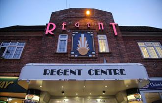 Front of the Regent Centre Building lit up at night time