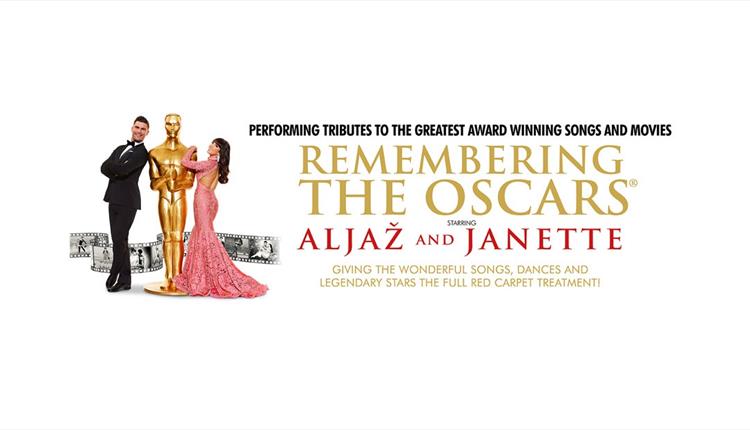 Man in black tux and woman in long sequin pink dress leaning up to Oscars golden trophy with text 'Remembering the Oscars' to the right