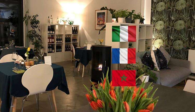 Interior room set up for dinner with three flags superimposed over the image; Italian, French, Moroccan