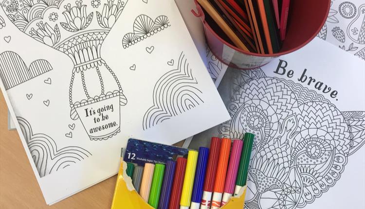 image shows felt tip pens, colouring sheets and crayons