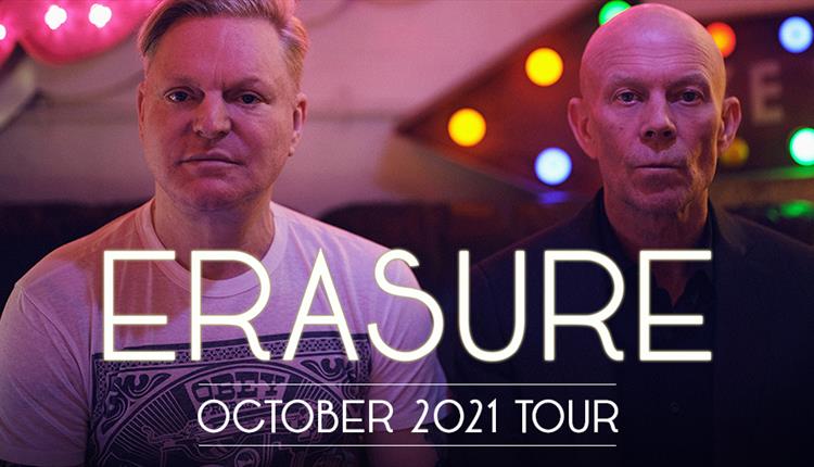 two members of the pop band Erasure looking towards camera with serious expressions and posing wearing tshirts