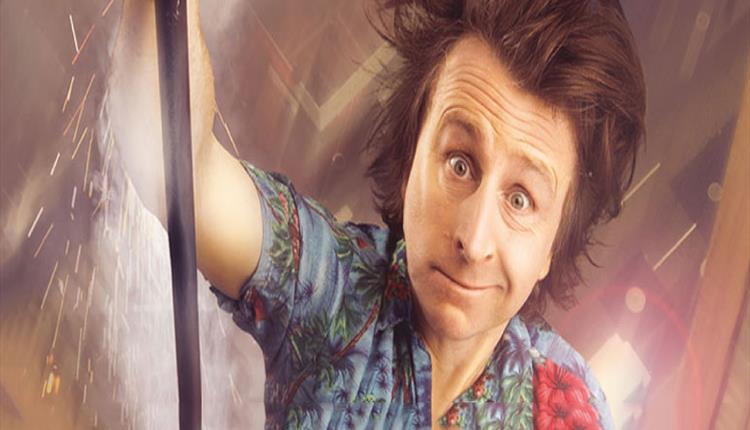 Milton Jones looking at camera with dishevelled hair and funny expression