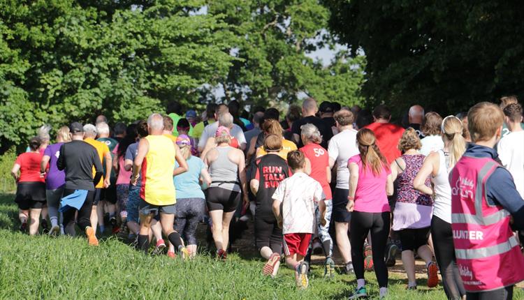 Parkrun participants in the grass and trees at Upton House.