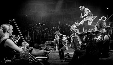 Black and white photograph showing a Bellowhead gig in full swing