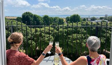 Two ladies toast the view from the balcony of Skyline Oasis