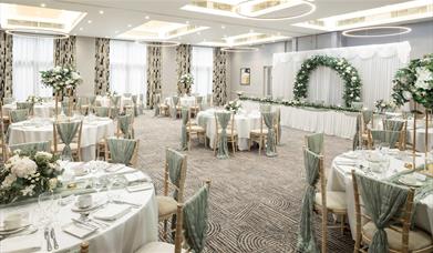 A function set up with tables and chairs for a wedding.
