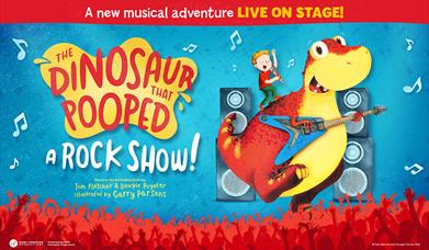 A cartoon drawing of a boy stood on a yellow and red dinosaur which is playing a guitar.