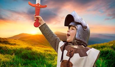 A child holding up a sword, for Medieval Mayhem at Fort Nelson