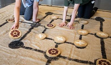 A Tudor board game laid out in cloth with large wooden counters