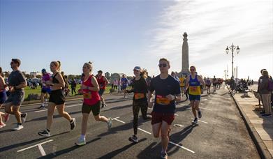 People taking part in the Great South Run, going past the War Memorial on Southsea Seafront