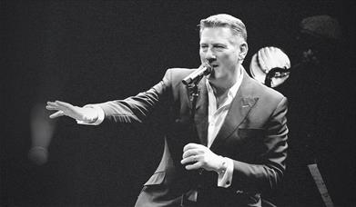 Black and white photograph of Tony Hadley mid-performance