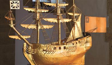 A gold-coloured model of a ship on display at Portsmouth Cathedral