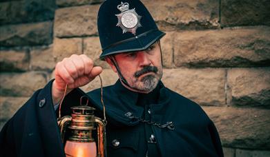 Image for Mystery at Fort Nelson showing a costumed police officer holding up a lamp