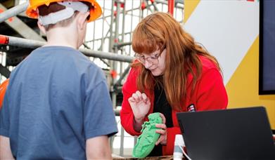 A woman showing a child one of the pests which could impact the ship.
