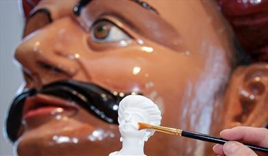 Photograph of a 3D printed miniature and the figurehead on which it was based.