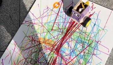A coded robot draws on a piece of paper