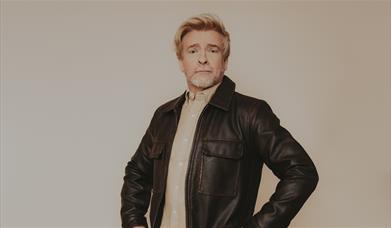 Photograph of Rhys Darby in a leather jacket