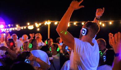 Photograph of a silent disco taking place, with punters in headphones