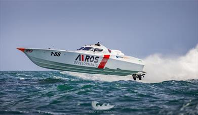 Photograph of a boat racing over the water - by Snap Photography