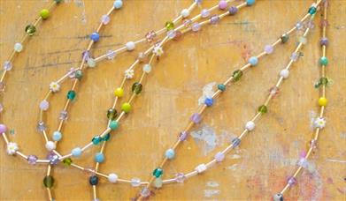 A number of beaded necklaces with different coloured beads.