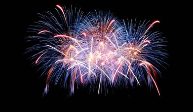 Stock photograph of fireworks going off against a black night sky