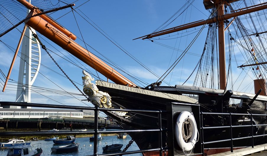 The exterior of HMS Warrior with the Spinnaker Tower in the distance