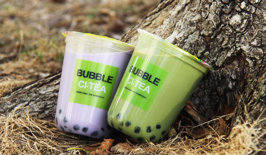 Two milky bubble teas near a tree