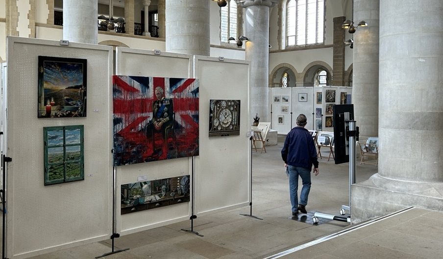 A man walking round an art exhibition at Portsmouth Cathedral.