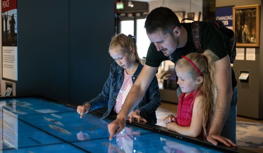 A family looks at an exhibit at the National Museum of the Royal Navy