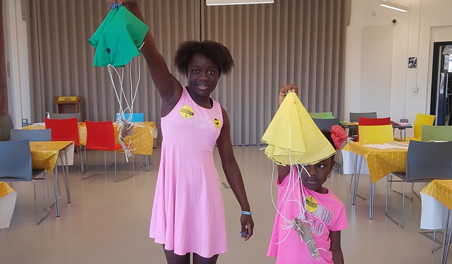 Two girls at The D-Day Story showing off the parachutes they've made