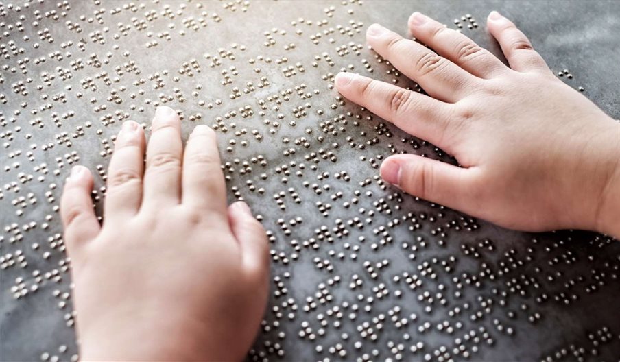 A person's hands as they read braille